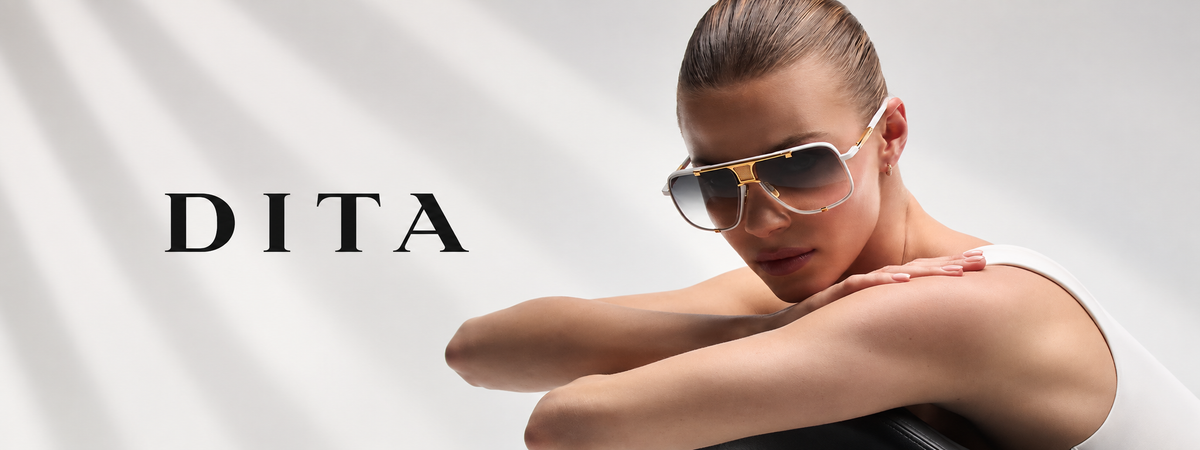 A model wearing DITA brand aviator sunglasses with gold frames and dark lenses, posed against a light gray background with diagonal shadows and the DITA logo on the left.